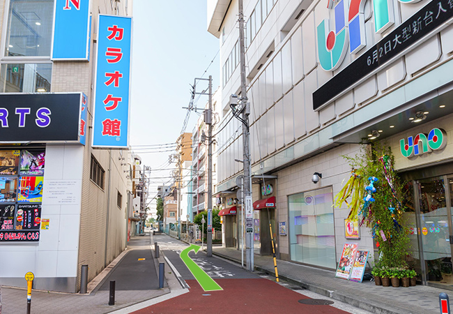 カラオケ館とティップネスの間の道を進み、交差点を右に曲がります。